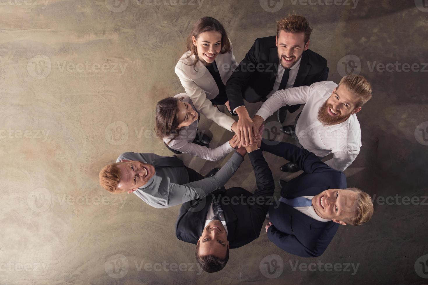 Business people putting their hands together. Concept of integration, teamwork and partnership photo