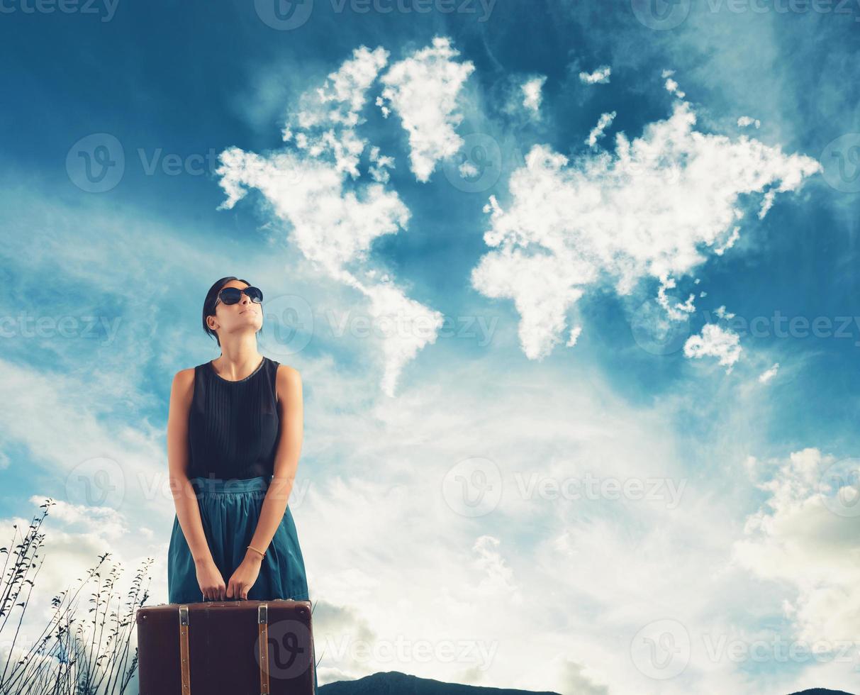 Girl with suitcase in her hand imagines traveling around the world photo