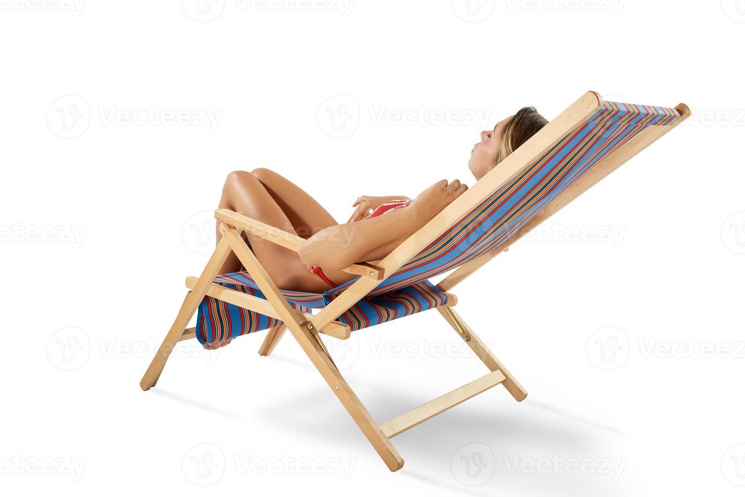 Girl tans on a deck chair on white background photo