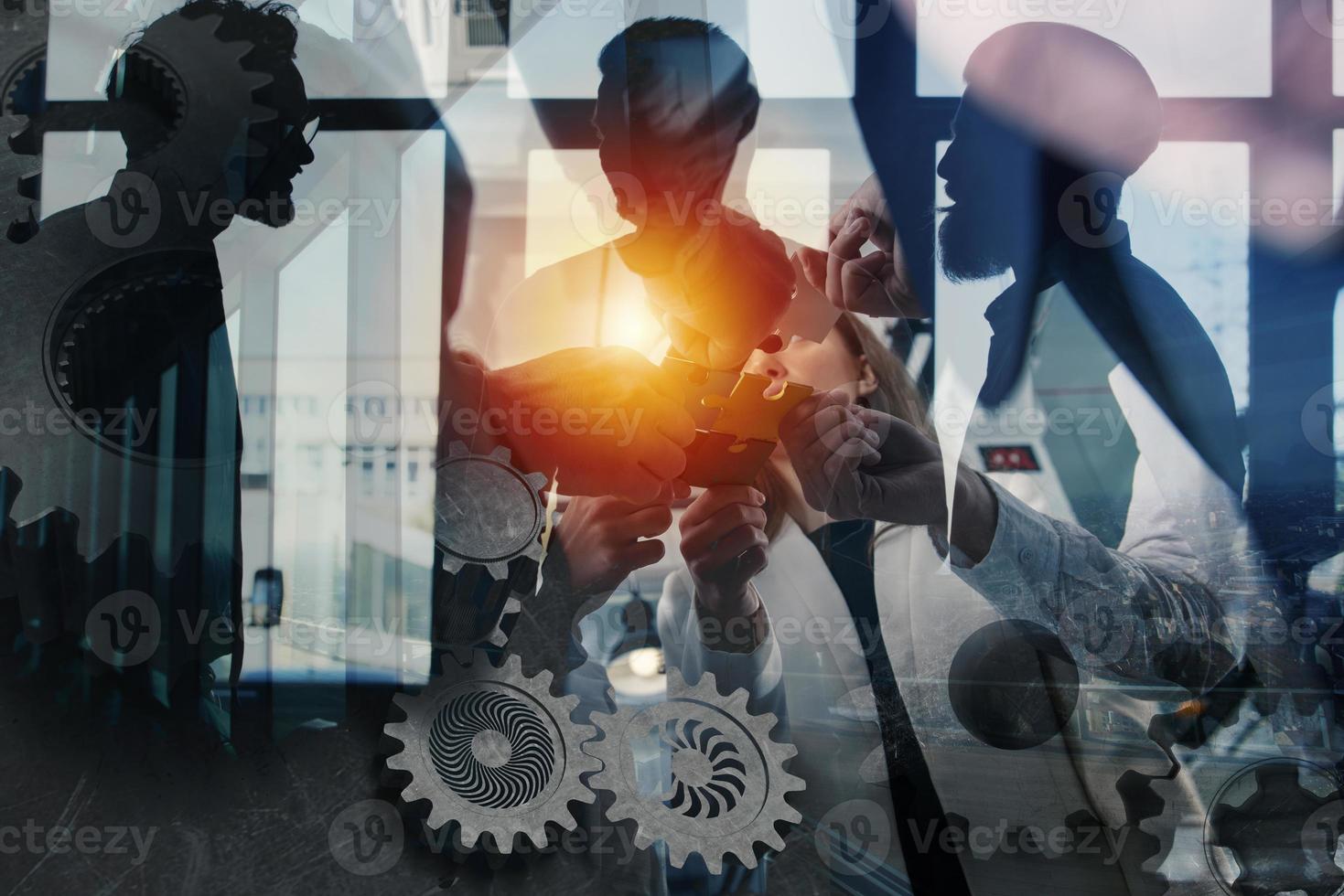 Teamwork of partners. Concept of integration and startup with puzzle pieces and gear overlay. double exposure photo