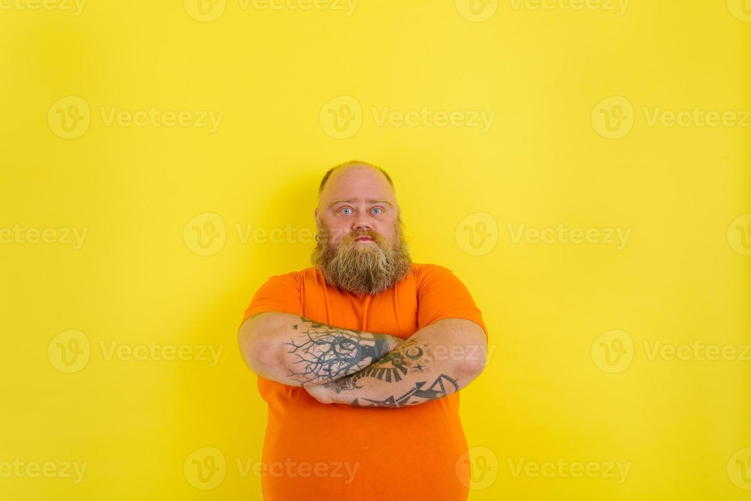 man with beard and tattoos has a serious expression photo