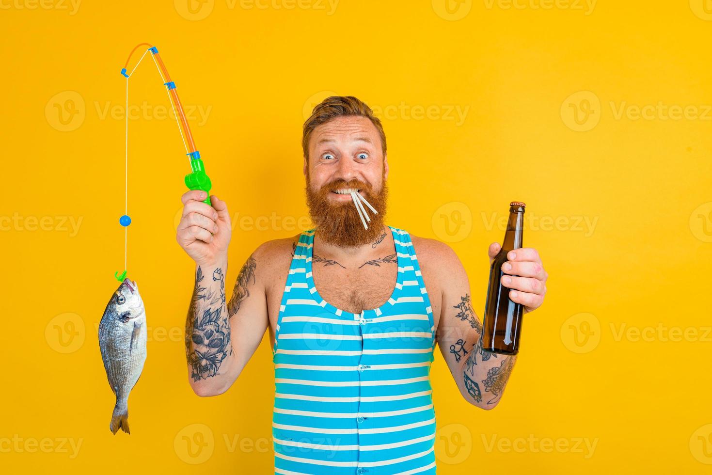 man with beard and swimsuit caught a fish photo