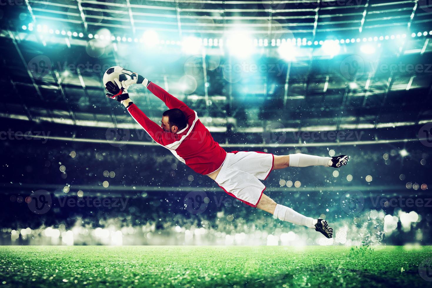 Goalkeeper catches the ball in the stadium during a football game. photo