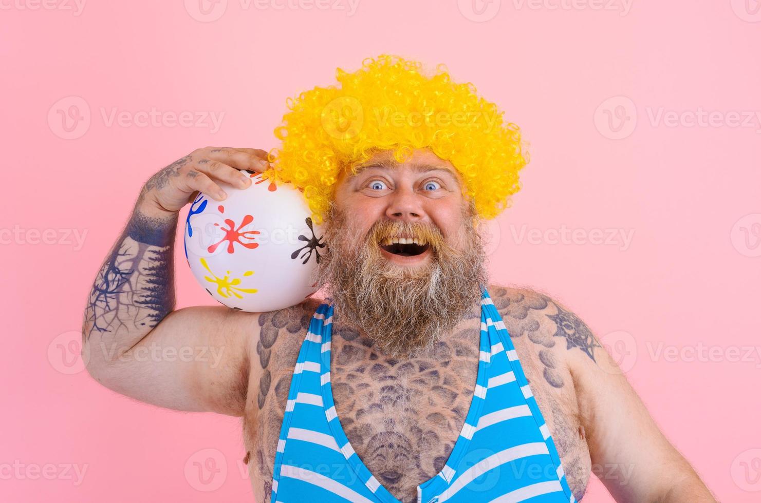 Fat happy man with beard and wig play with the ball photo