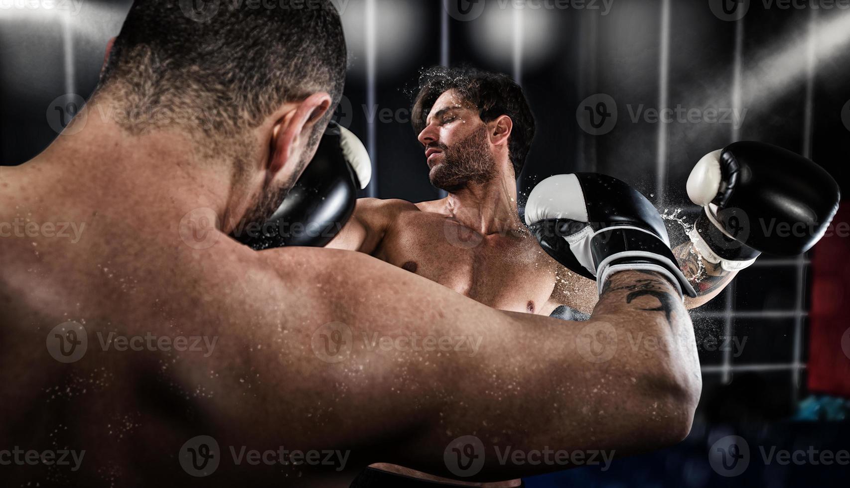 Boxer punches his opponent during boxing competition photo