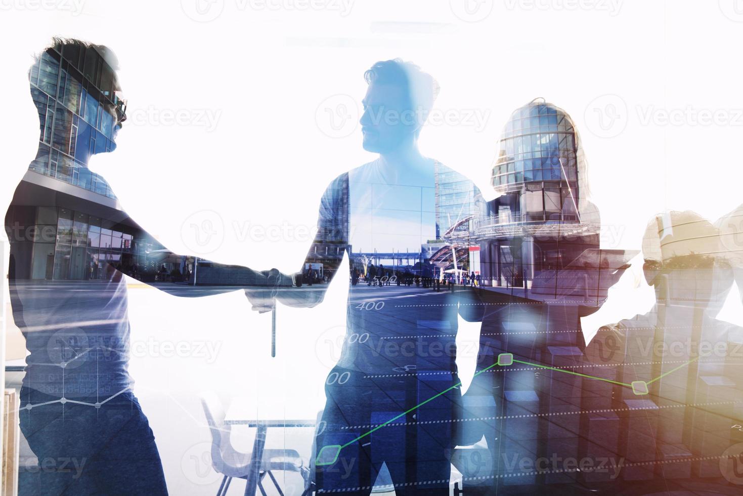 Silhouette of young workers shaking hands in the office. concept of teamwork and partnership. double exposure photo