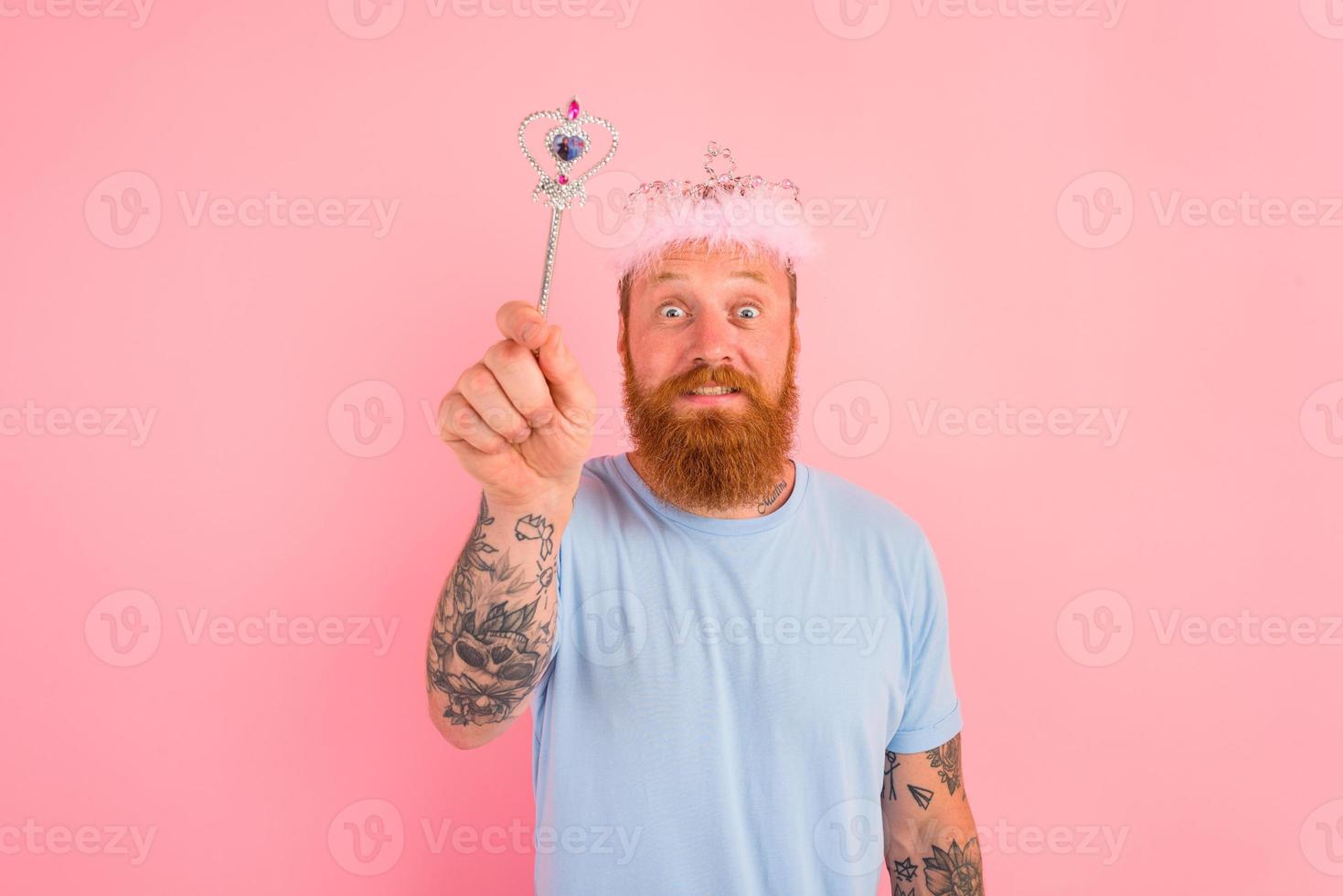 Amazed man with beard and tattoos acts like a princess of a tale photo