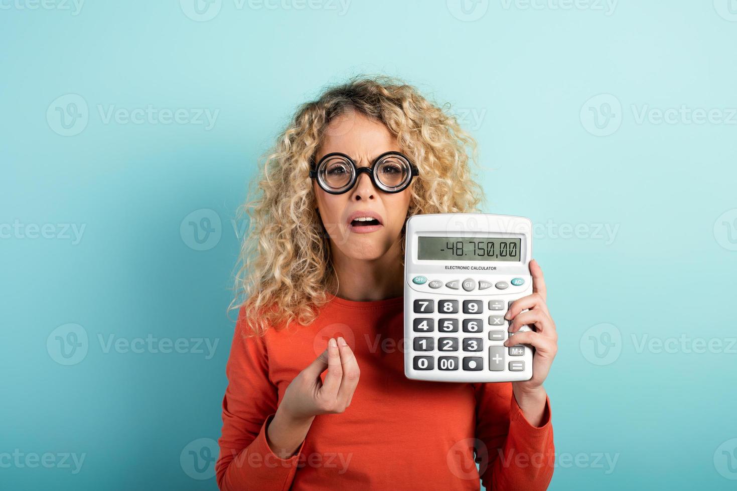 Accountant girl has some problems with the sums. Cyan background photo