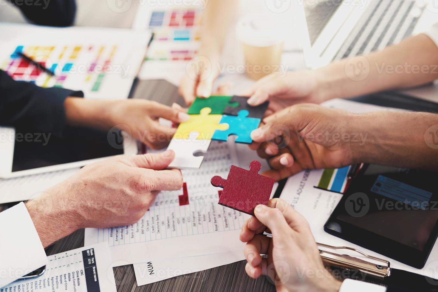 Team of businessmen work together to build a puzzle. Concept of unity and partnership photo
