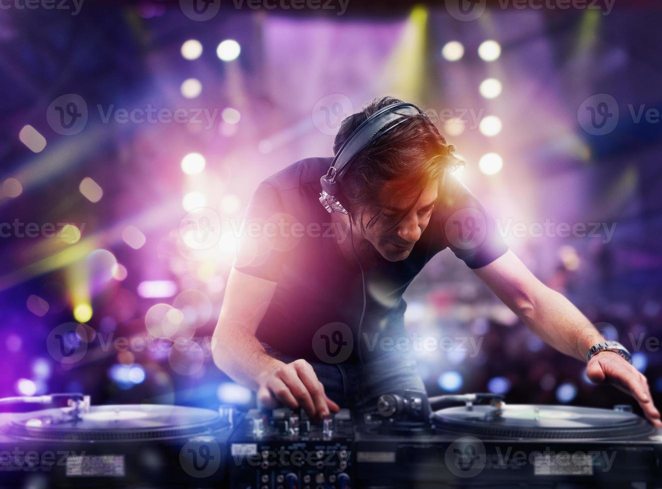 DJ playing music at the night discotheque photo