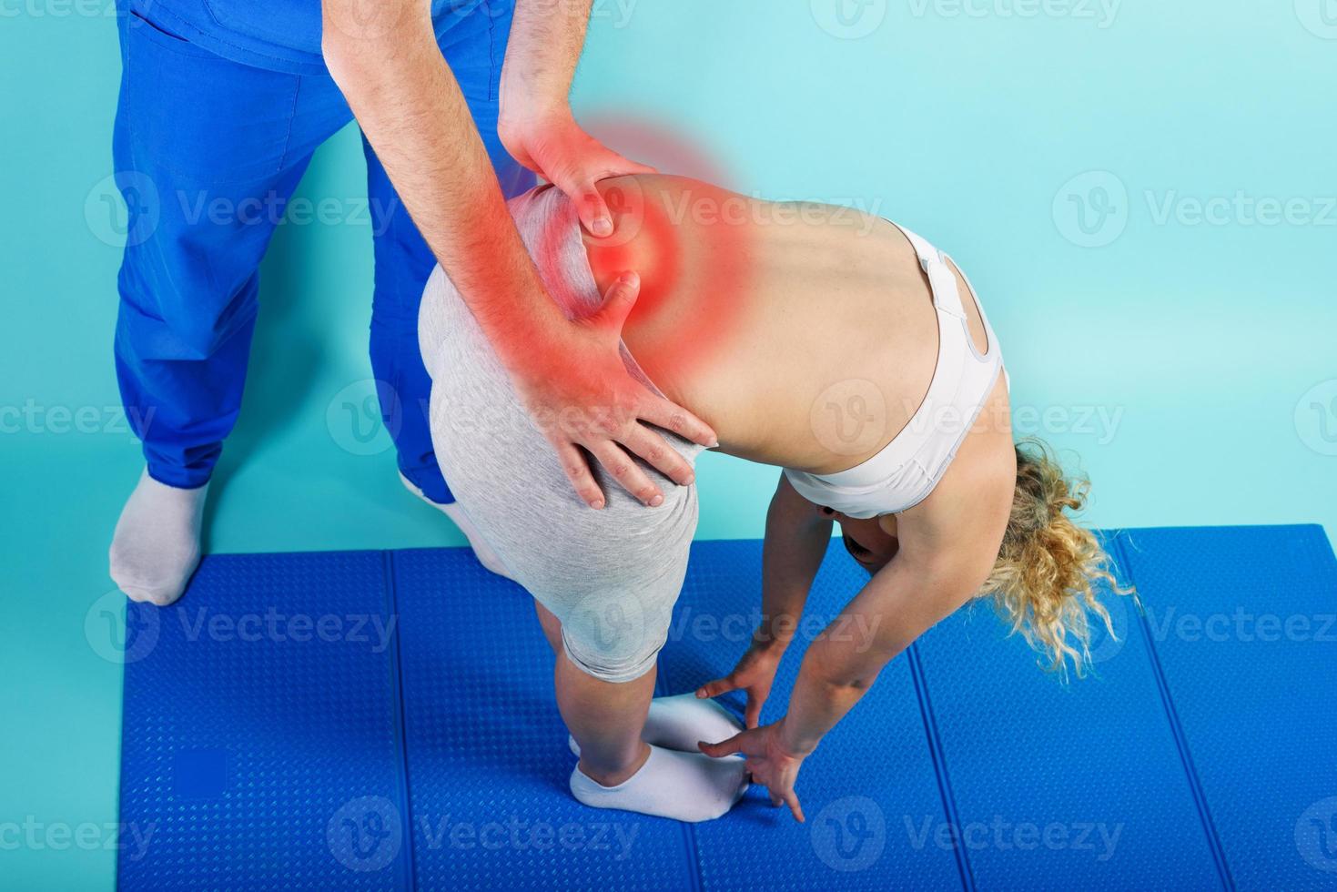 Girl performs exercises with a physiotherapist. Cyan background photo