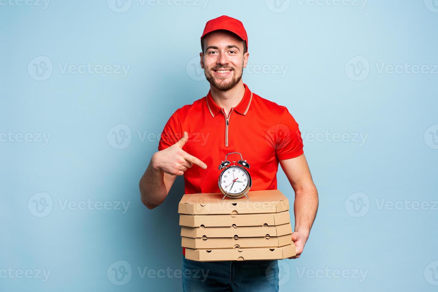 Deliveryman is punctual to deliver quickly pizzas. Cyan background photo