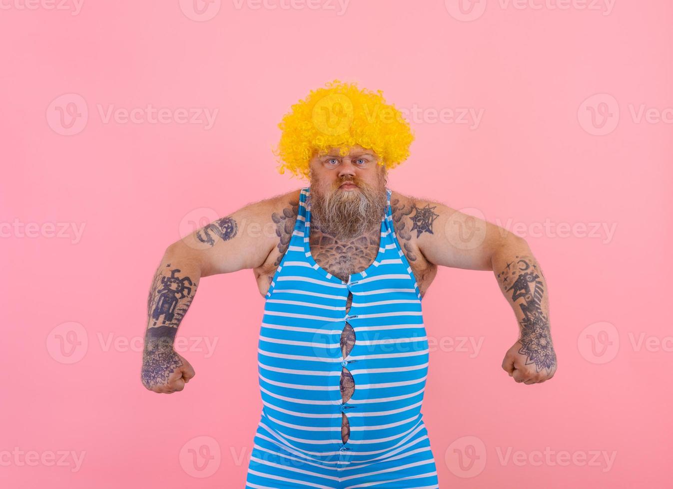 Angry man with yellow wig and swimsuit is ready to the summer photo
