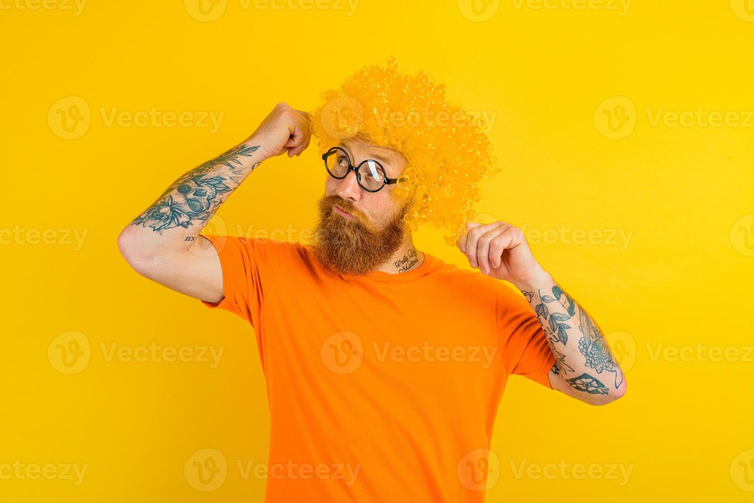 Thoughtful man with beard, yellow wig and glasses photo