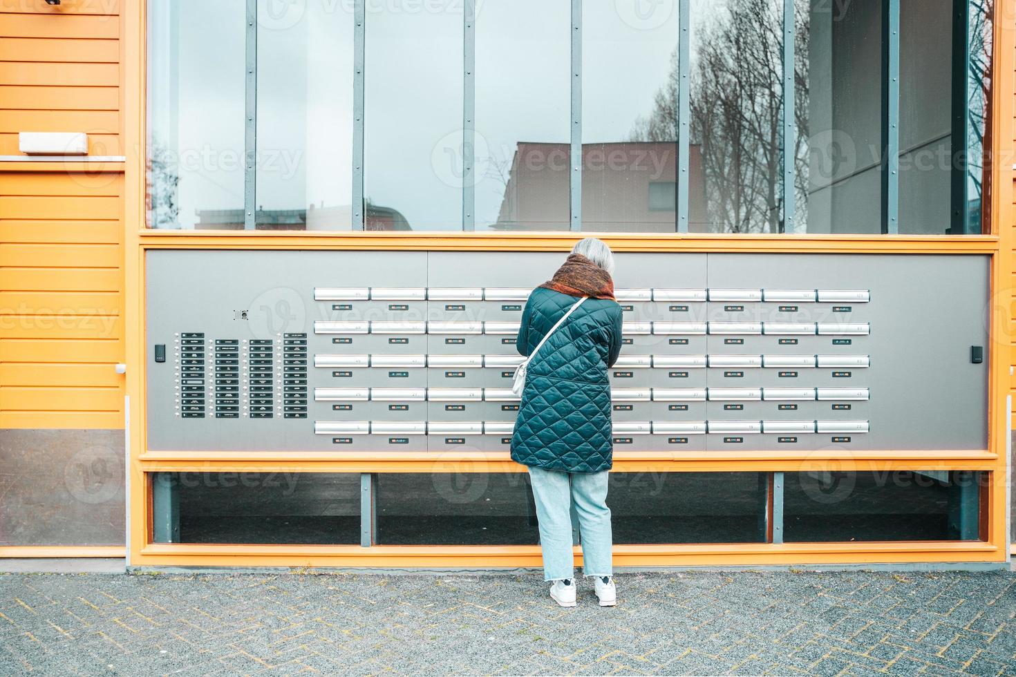 mayor mujer abre el buzón a cheque para nuevo correos foto