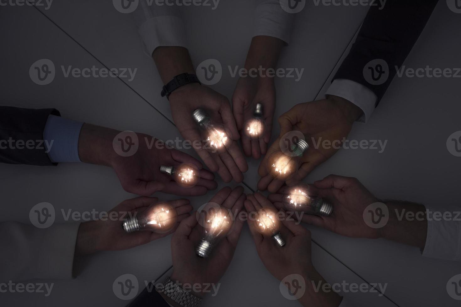 Teamwork and brainstorming concept with businessmen that share an idea with a lamp. Concept of startup photo