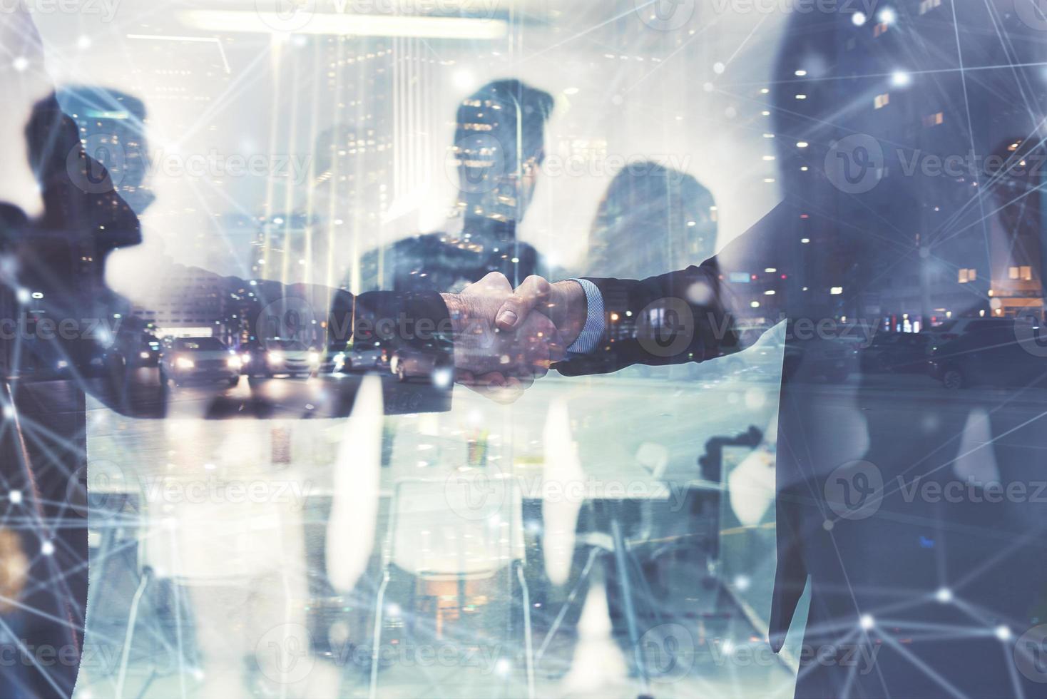 Handshaking business person in office. concept of teamwork and partnership. double exposure photo