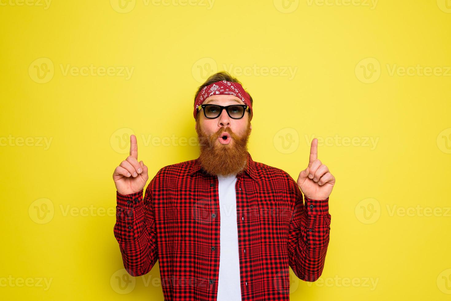 Happy man with beard and bandana in head cries indicates something photo