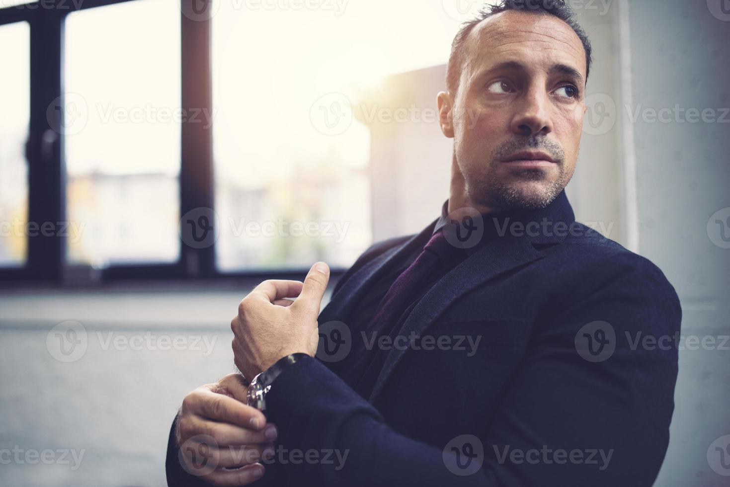 Pensive businessman against the window in a modern office photo