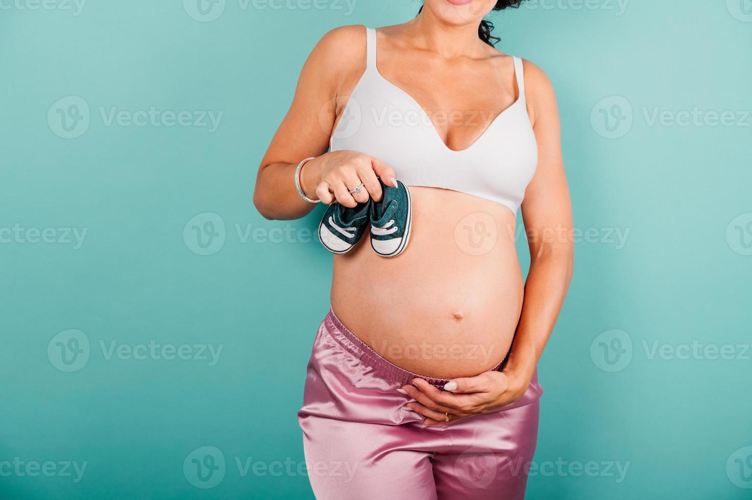 Pregnant woman expecting a child caresses her belly photo