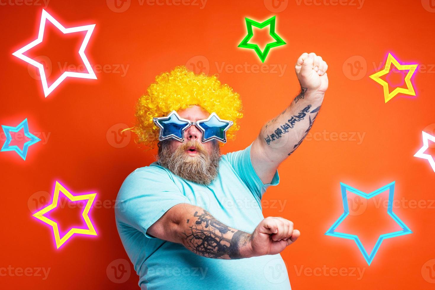 Fat man with beard, tattoos and sunglasses dances music on a disco photo