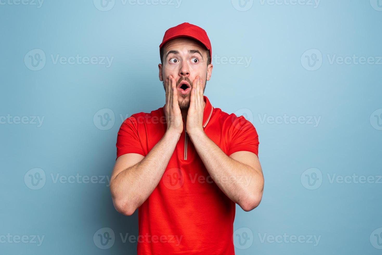 Courier with amazed and surprised expression face. Cyan background photo