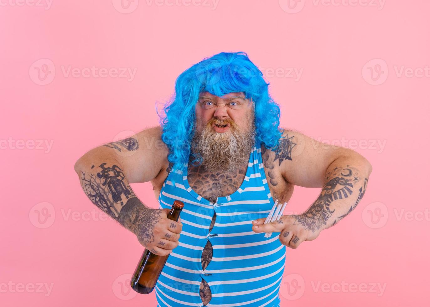 Fat man with beard and wig smokes cigarettes and drinks beer photo