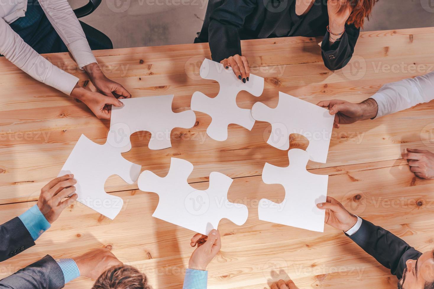 Teamwork of partners connect puzzle pieces as integration and startup photo
