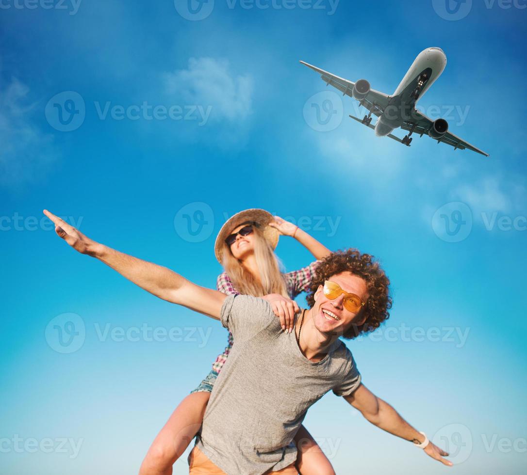 Happy smiling couples playing at the beach with aircraft in the sky photo