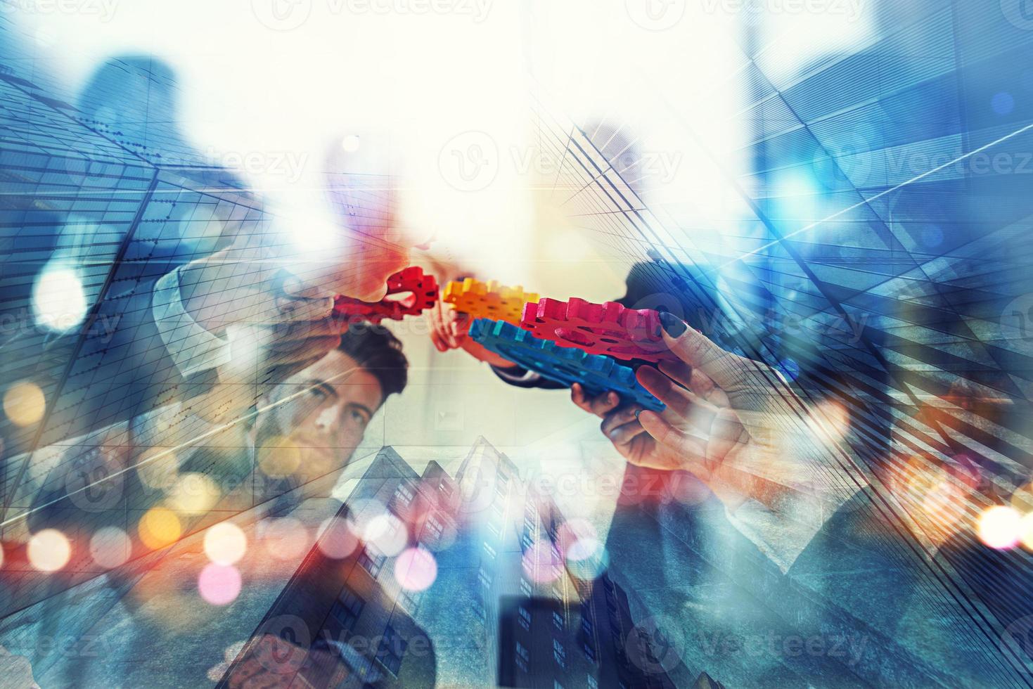 Working group of businessmen find the agreement by holding a piece of gear in hand. concept of teamwork and business partnership. double exposure photo