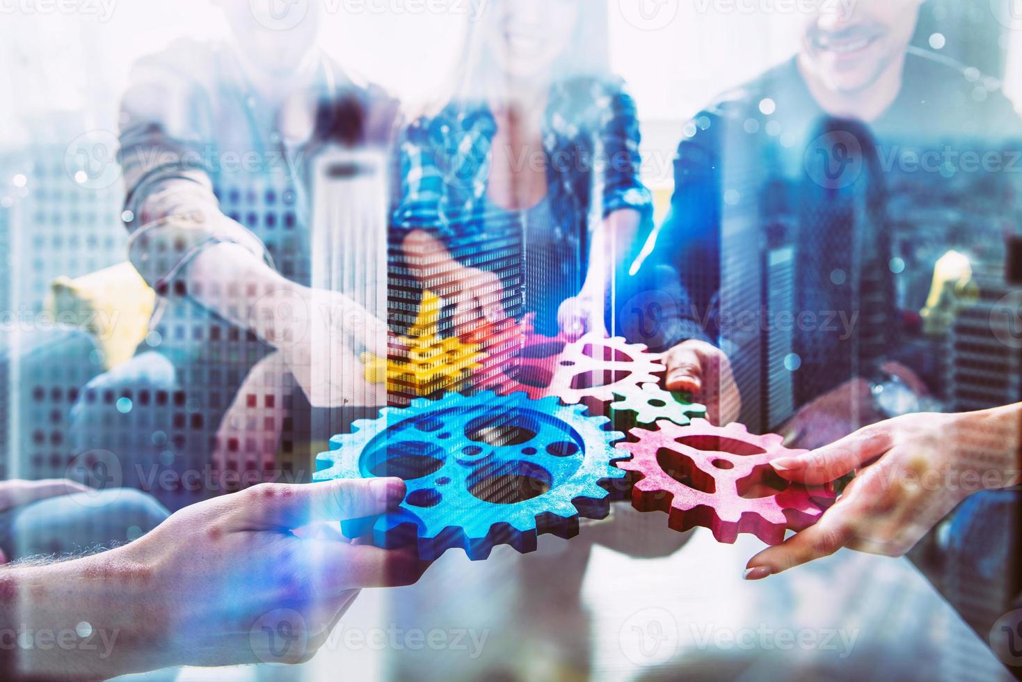 Working group of businessmen find the agreement by holding a piece of gear in hand. concept of teamwork and business partnership. double exposure photo