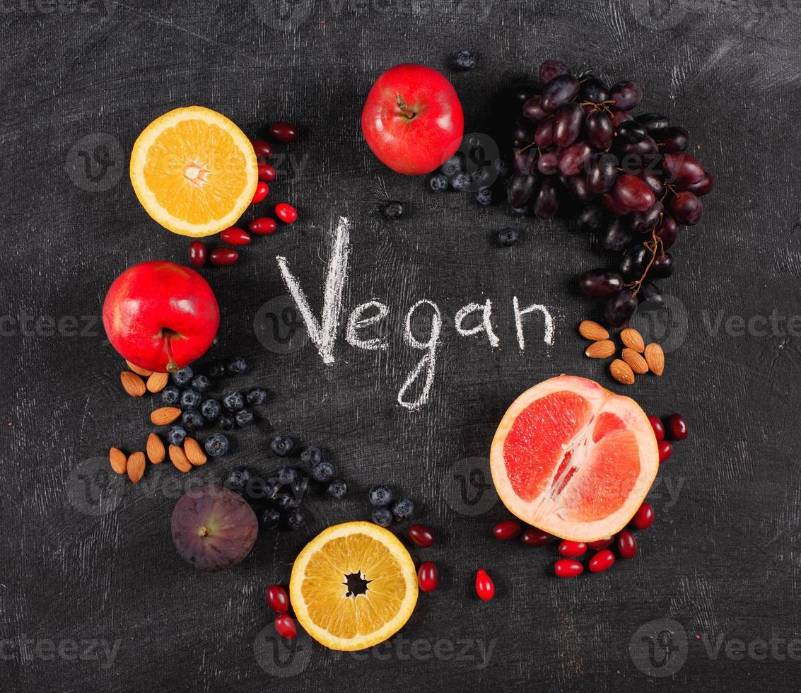 Mixed healthy fruit over a blackboard background. Concept pf vegan and genuine fruit photo