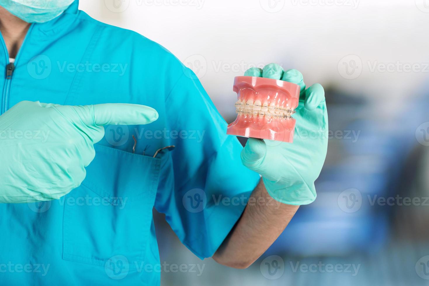 Dentist shows how to apply a brace photo