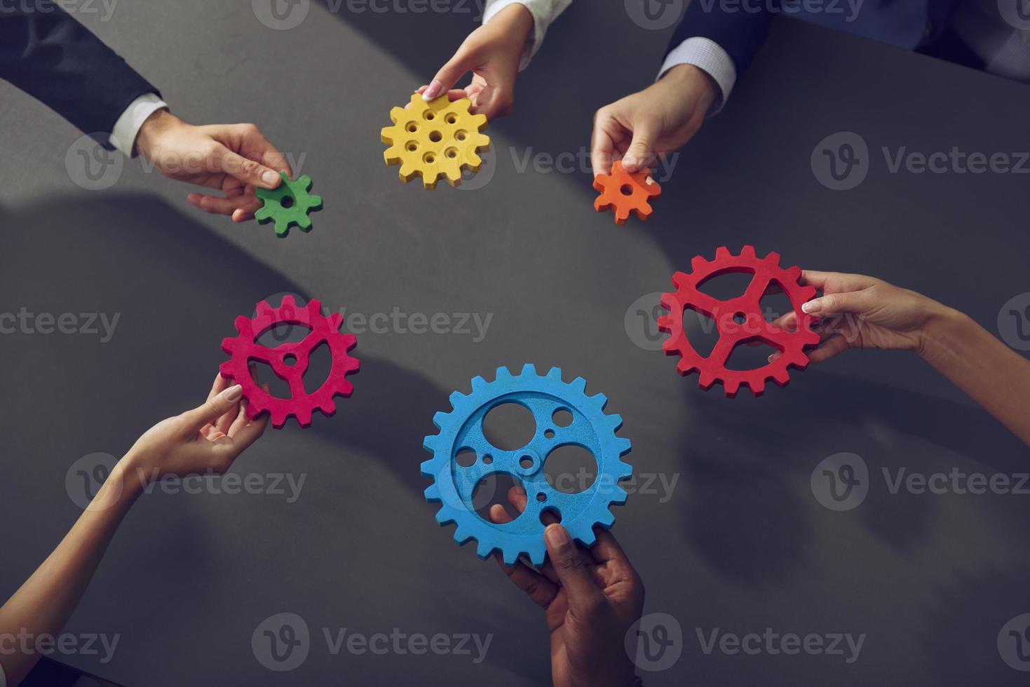 Business team connect pieces of gears. Teamwork, partnership and integration concept. photo