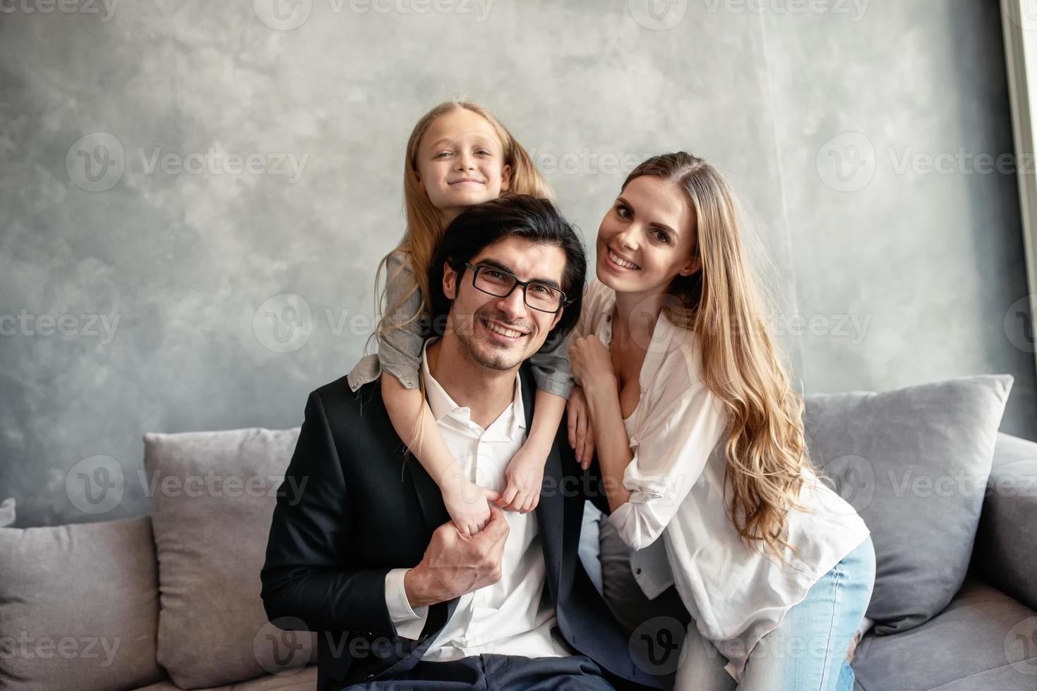 Happy little girl play with her mother and father photo