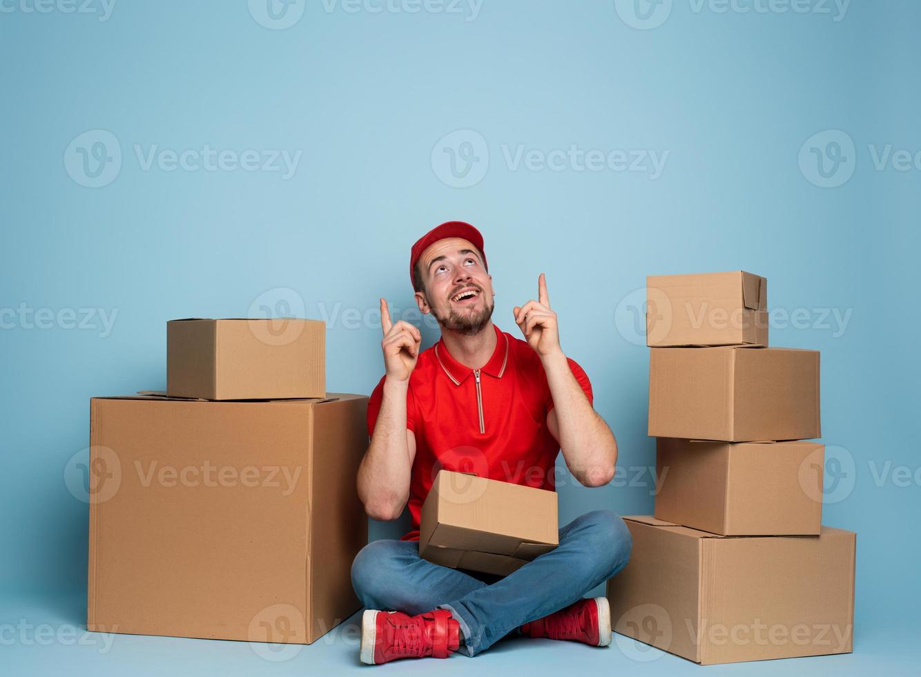 Courier is happy and indicates something above. Studio on cyan background photo