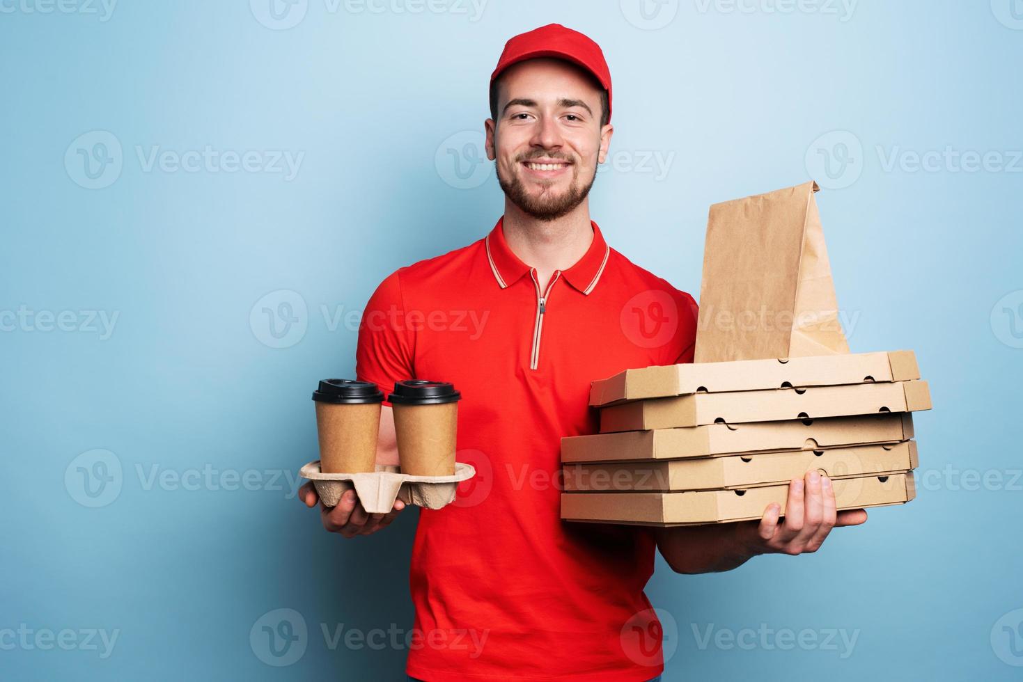 Courier is happy to deliver hot coffee and pizzas. Cyan background photo