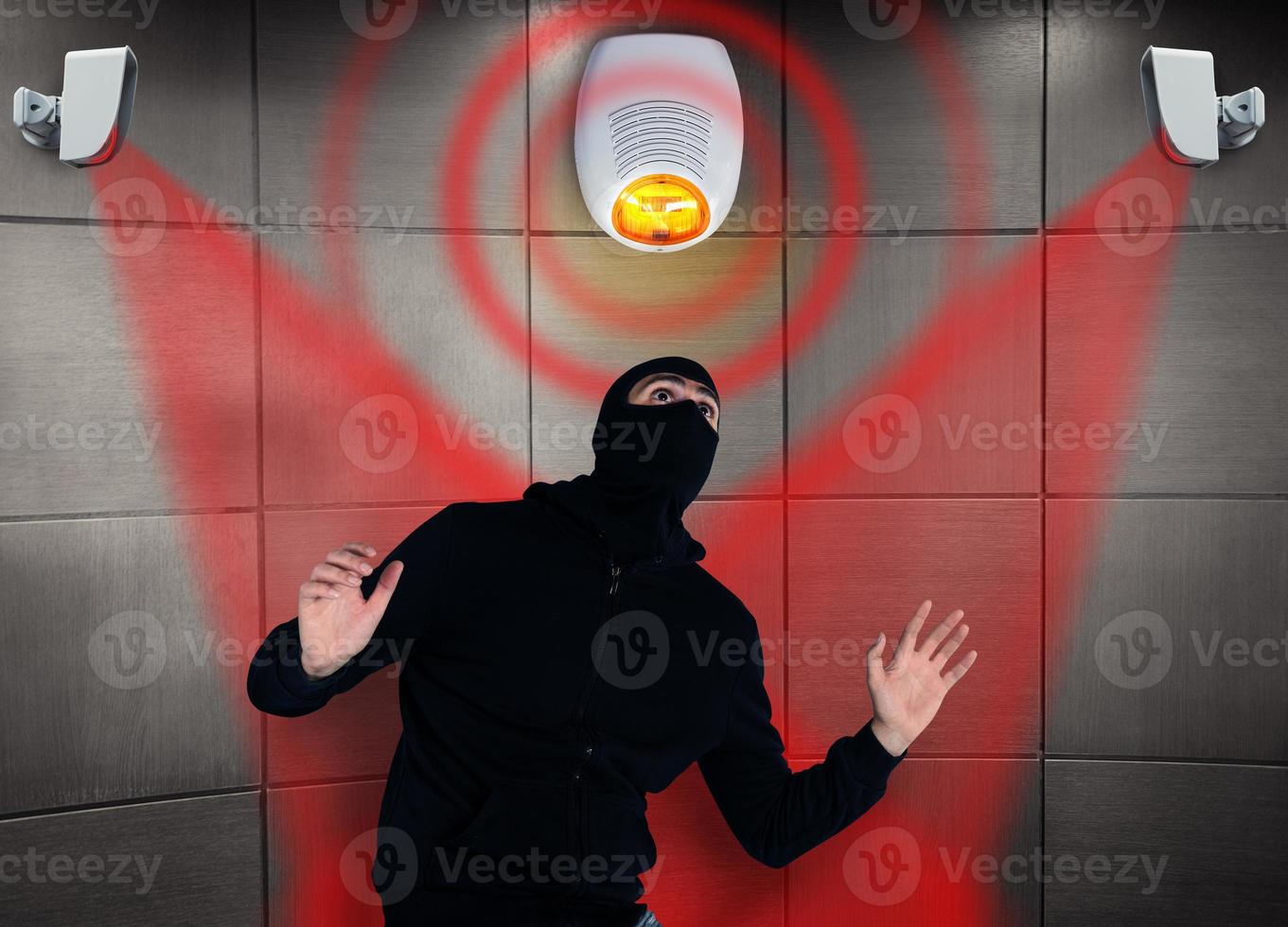 Thief with balaclava was spotted trying to steal in a apartment from the security alarm system. Scared expression photo