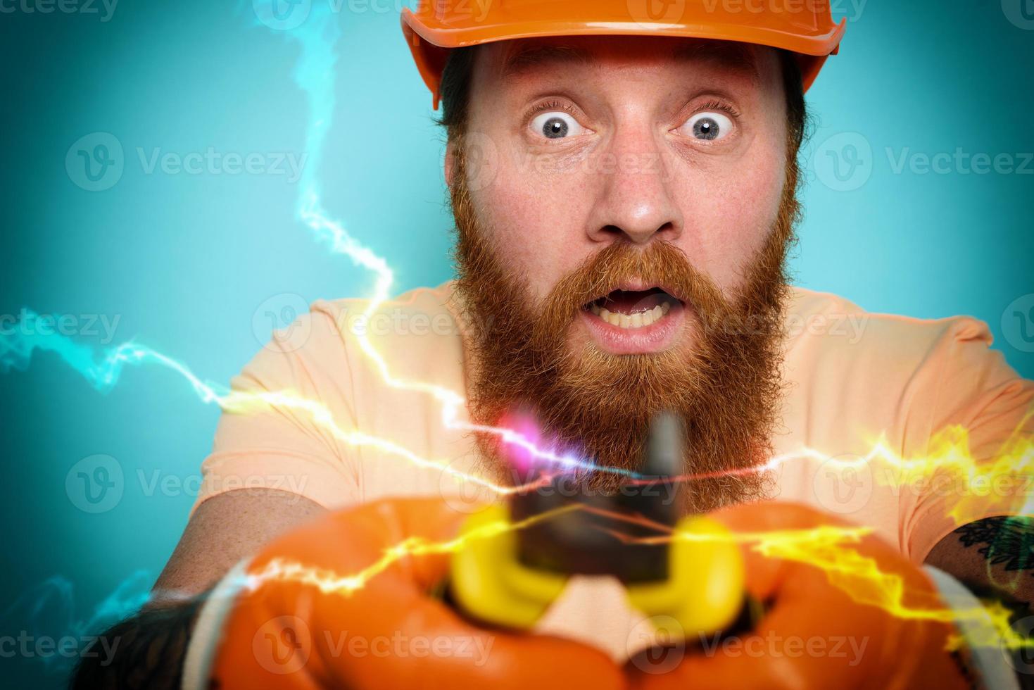 Incompetent worker electrician is unsure about his work. cyan background photo