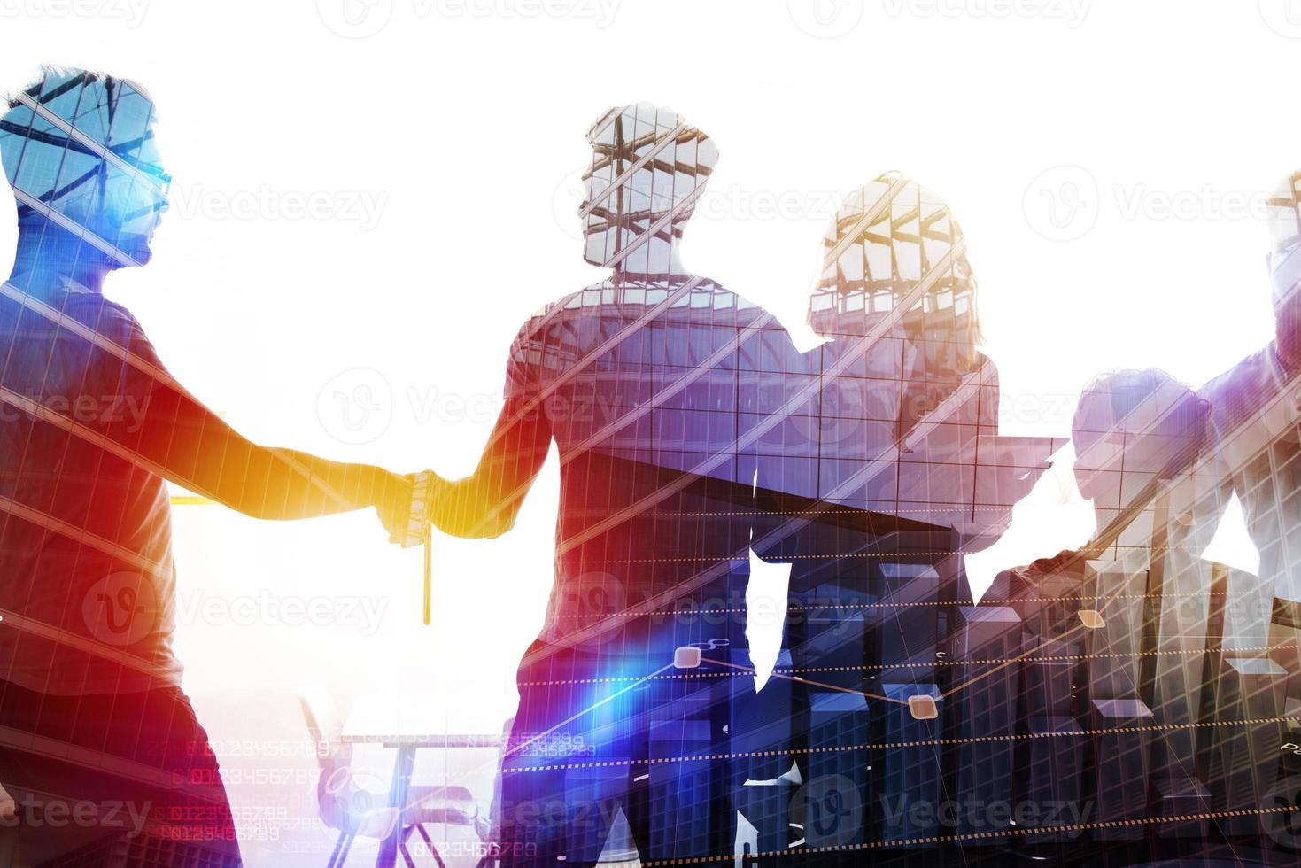 Silhouette of young workers shaking hands in the office. concept of teamwork and partnership. double exposure photo