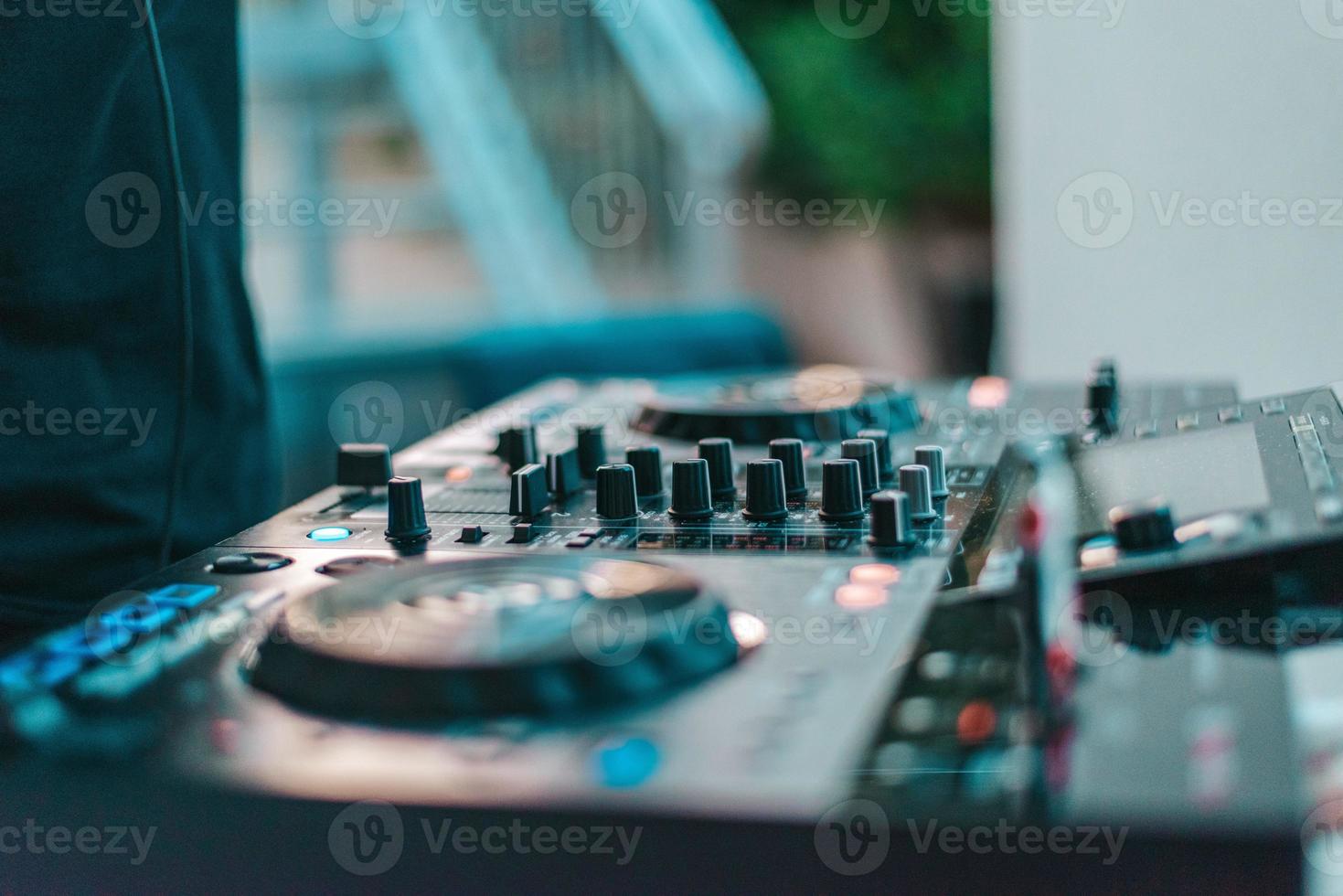 Dj plays disco music with his consolle in a pub photo