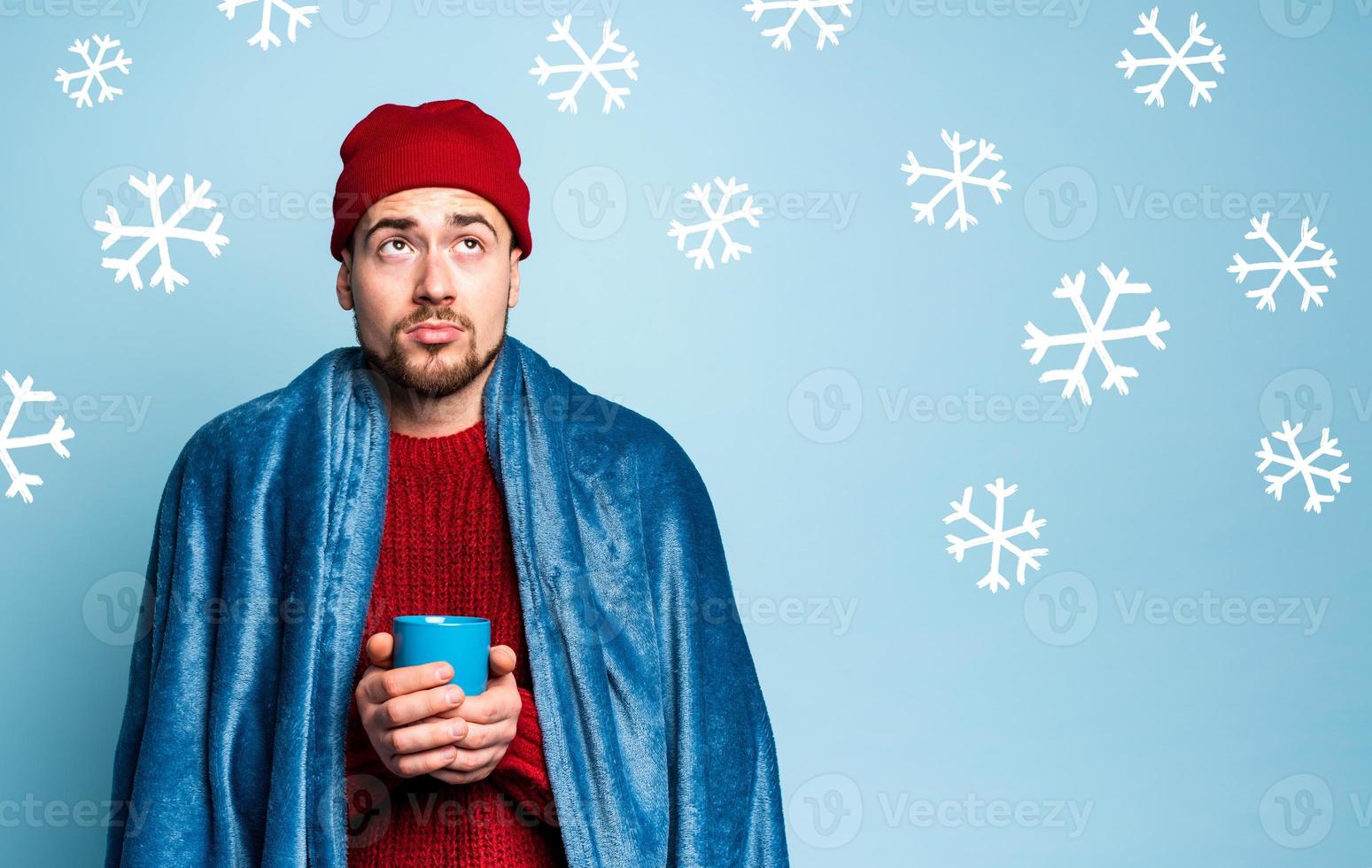 Boy caught a cold and drinks hot the. Cyan background. Concept of illness photo