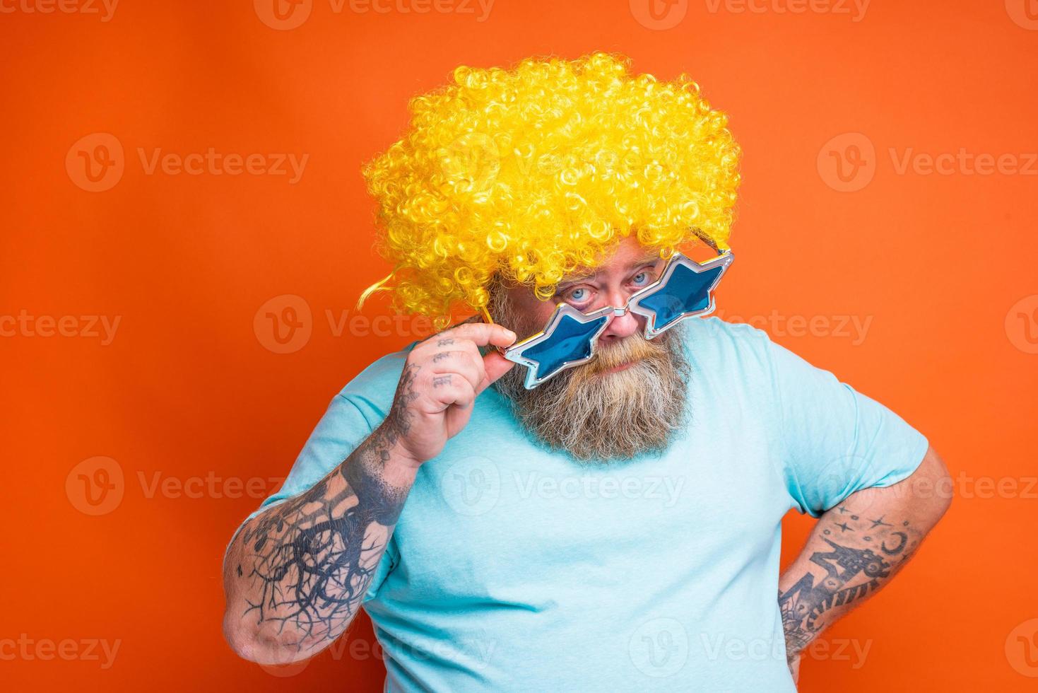 Fat doubter man with beard, tattoos and sunglasses has doubt about something photo