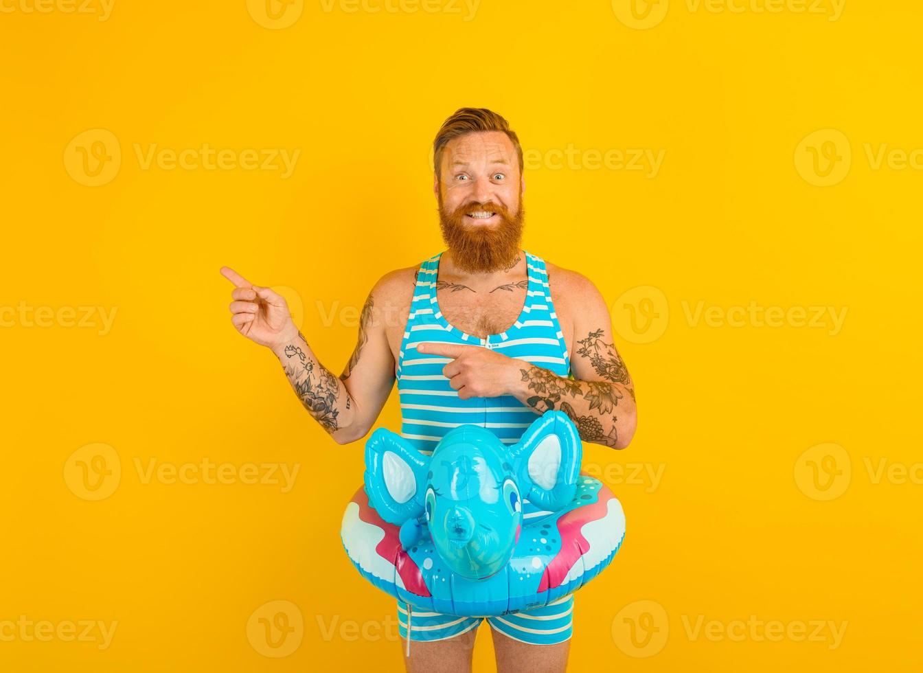 Happy man with inflatable donut with elephant is ready to swim photo