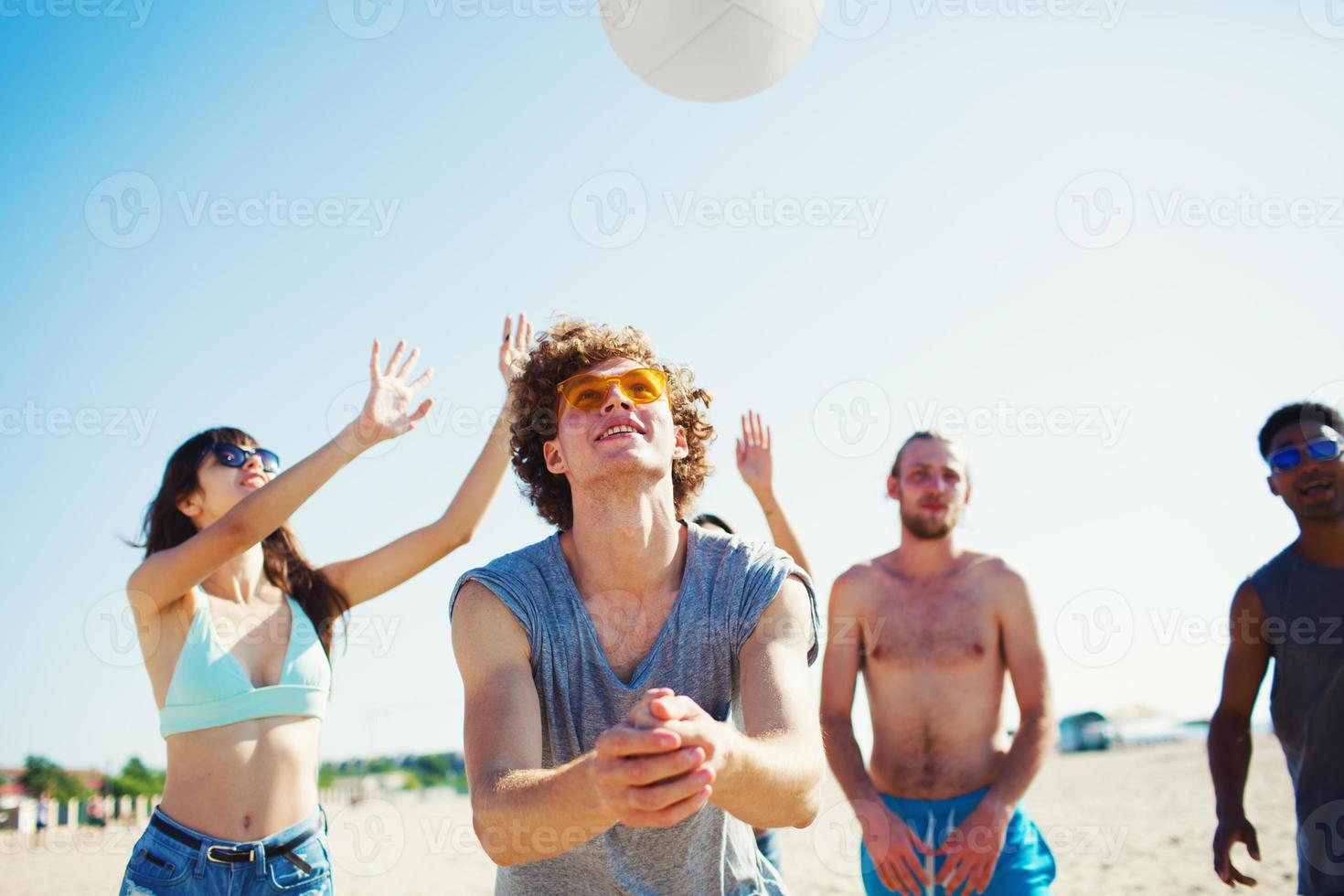 Group of friends playing at beach volley at the beach photo