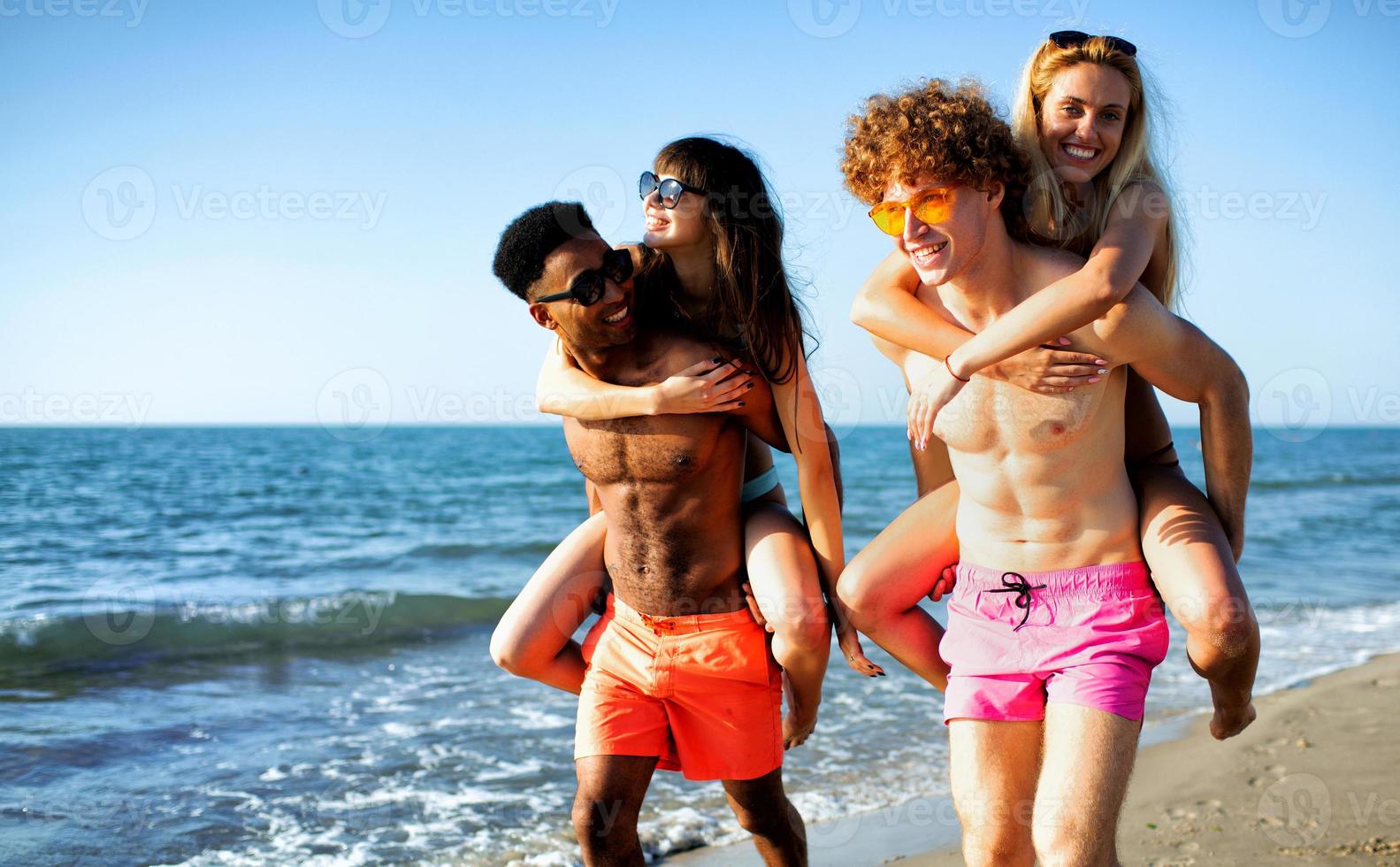 Happy smiling couples playing at the beach photo