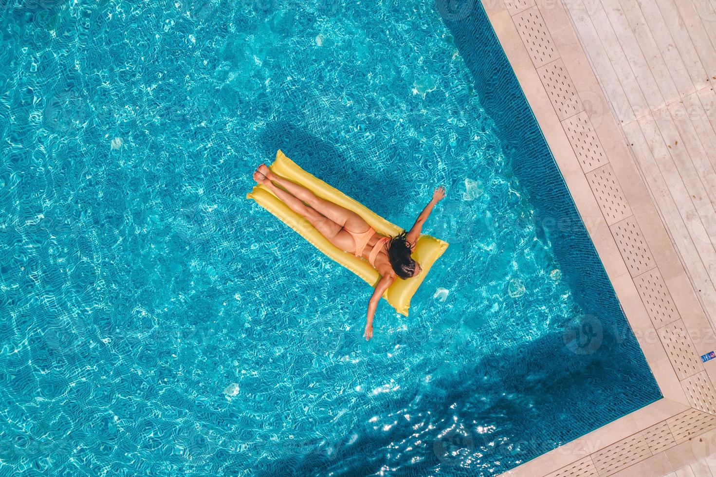 Girl in swimsuit who tan in a swimming pool photo
