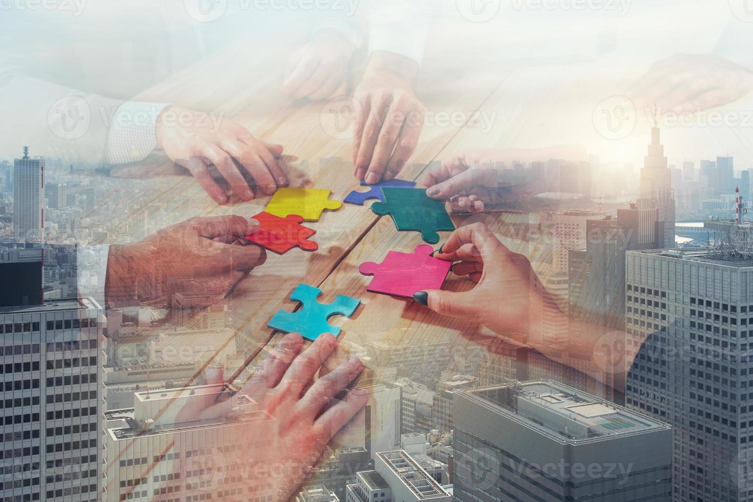 Business team connect pieces of puzzle like a teamwork and partners on city buildings background photo