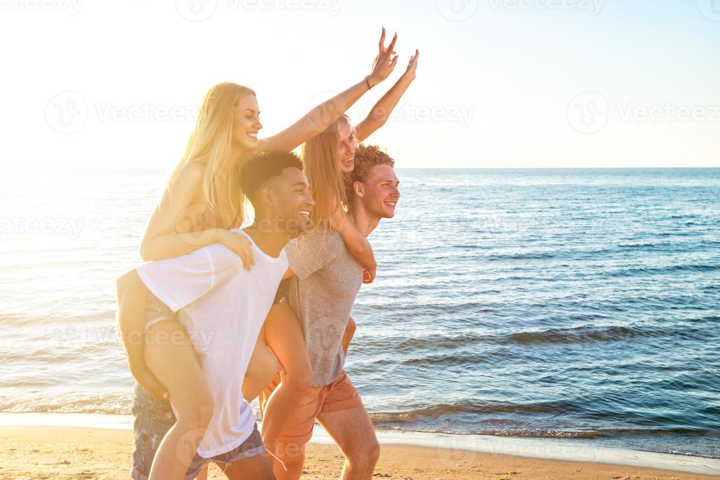 Happy smiling couples playing at the beach photo