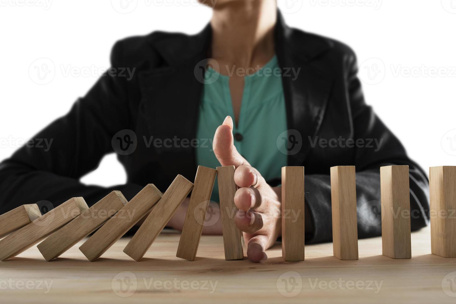 Businesswoman stops a chain fall like domino game. Concept of preventing crisis and failure in business. photo